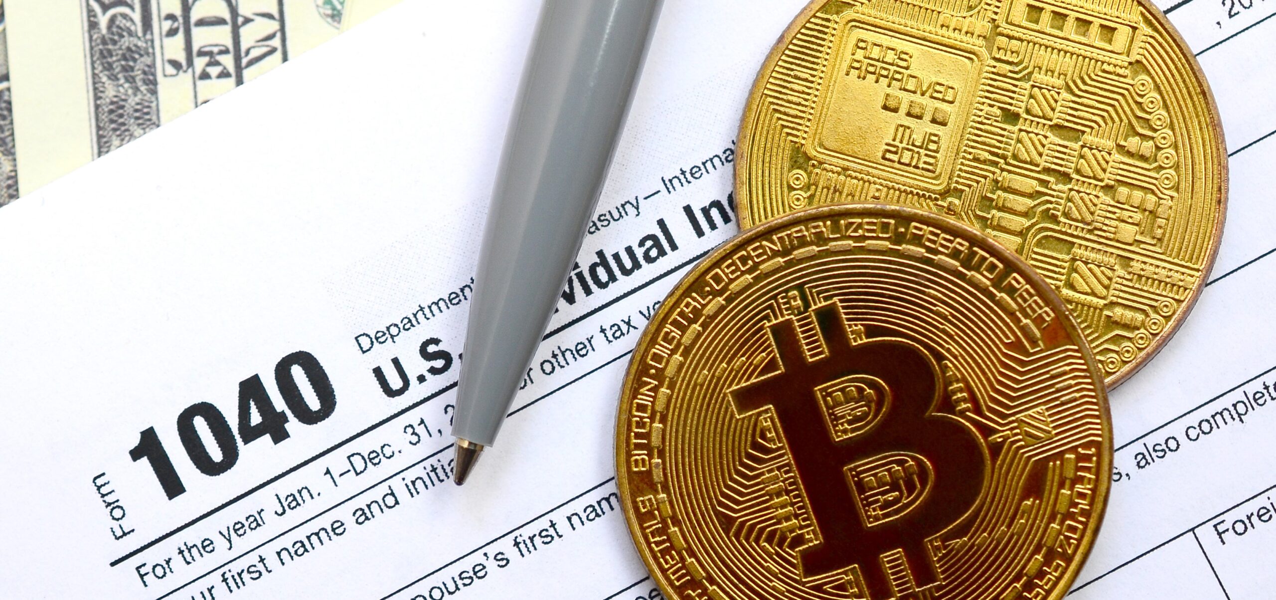 The pen, bitcoins and dollar bills is lies on the tax form 1040 The pen, bitcoins and dollar bills is lies on the tax form 1040 U.S. Individual Income Tax Return. The time to pay taxes